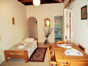 a room with a table and a bed and a dining room at Anemona Apartments and Studios in Vasilikos