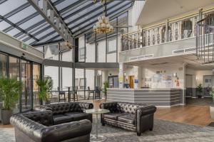a living room with leather furniture and a glass ceiling at Britannia Hotel Wigan in Standish