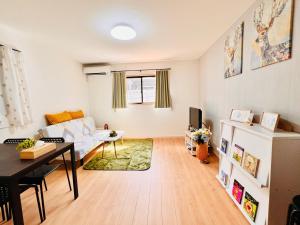 a living room with a white couch and a table at Hana Home - New Cozy House with 4 bedrooms - 10min from Umeda in Osaka