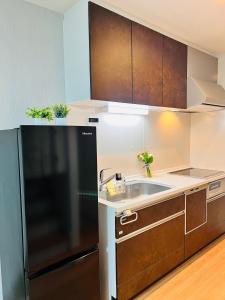 a kitchen with a black refrigerator and a sink at Hana Home - New Cozy House with 4 bedrooms - 10min from Umeda in Osaka +30 photos