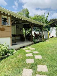 a garden with a patio with a table at Maison confortable Le Diamant 40 m² avec piscine in Le Diamant +11 photos