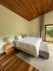 une chambre avec un grand lit et une fenêtre dans l'établissement Refugio Monteverde house, privacy & ocean view!, à Monteverde Costa Rica