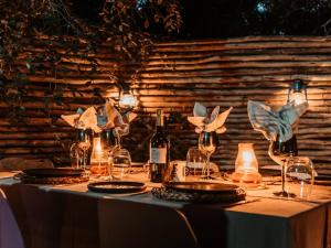 un tavolo con bicchieri e bottiglie di vino sopra di Grace of Africa, Couples 5 STAR Nature Lodge a Marloth Park