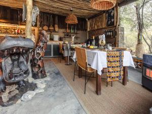 a dining room with a table and a fireplace at Grace of Africa, Couples 5 STAR Nature Lodge in Marloth Park