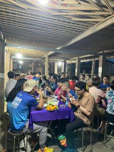 Un grupo de personas sentadas en una mesa comiendo comida en Mai Tiến homestay 188, en Mai Chau