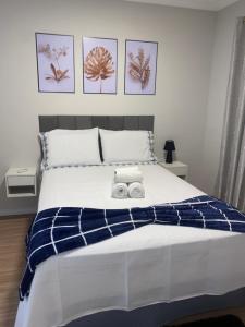 a bedroom with a bed with two towels on it at Flórida vivo bem! in São Roque