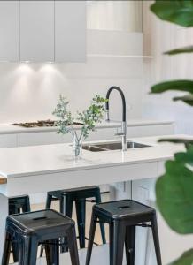 una cucina con due sgabelli neri e un lavandino di Parkvue 11 What a Spot a Mornington