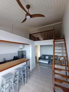 a living room with a ceiling fan and a loft at Appartement charmant avec vue sur mer à Schoelcher - 90 m², calme in Schœlcher