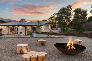 a fire pit in the middle of some logs at LUXE POINT in Blairgowrie