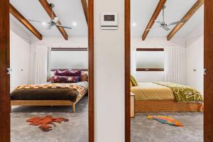 a bedroom with two beds and a mirror at LUXE POINT in Blairgowrie
