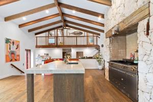an open kitchen with wooden ceilings and a stone wall at LUXE POINT in Blairgowrie