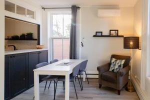 ein Wohnzimmer mit Tisch und Stühlen und eine Küche in der Unterkunft County Cove - Picton Suite - downtown Wellington in Wellington