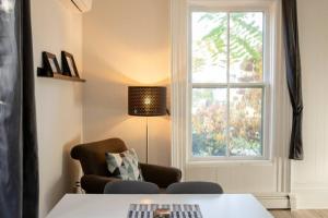 ein Wohnzimmer mit einem Tisch und einem Fenster in der Unterkunft County Cove - Picton Suite - downtown Wellington in Wellington