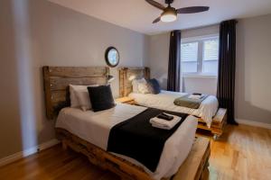 a bedroom with two beds and a ceiling fan at Vineyard & Craft House - Rare 6 bedroom Gem in Picton in Picton