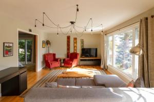 a living room with a couch and red chairs at Vineyard & Craft House - Rare 6 bedroom Gem in Picton in Picton