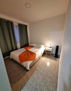 a bedroom with a large bed and a night stand at Kira Apartahotel in Buenavista