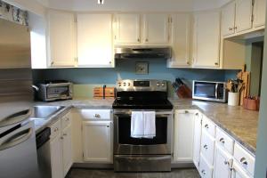 a kitchen with white cabinets and a stove top oven at The White Mountain Escape in Woodstock