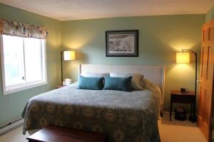 a bedroom with a bed with two blue pillows at The White Mountain Escape in Woodstock