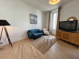a living room with a couch and a flat screen tv at Saint Goustan à pied! Joli appartement 2p in Auray