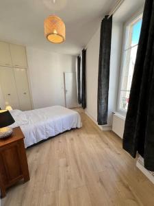 a bedroom with a white bed and a wooden floor at Saint Goustan à pied! Joli appartement 2p in Auray