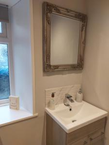 a bathroom with a sink and a mirror on the wall at Hill Street Cottage in Portpatrick +54 photos