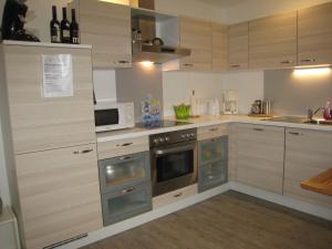 a kitchen with stainless steel appliances and wooden cabinets at Eulennest in Tarp
