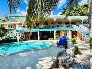 a resort with a swimming pool and a house at Coral Cove Inn in Maya Beach