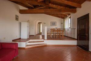 a living room with a red couch and wooden ceilings at Villetta Mare Blu With Pool, Country Village, Stintino in Cuile Pazzoni