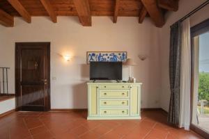 a room with a dresser with a television on it at Villetta Mare Blu With Pool, Country Village, Stintino in Cuile Pazzoni