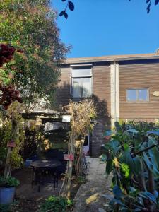 un jardin avec une table et un bâtiment dans l'établissement Duplex14h 1er étage jardinet 1 parking ou studio14B rdc terrasse sans parking, à La Rochelle