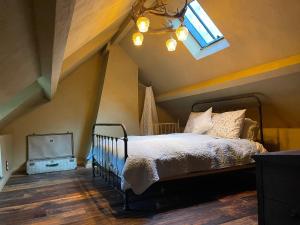 a bedroom with a bed and a skylight at La Petite Foret 17th Cent Cottage Near Durbuy in Clavier
