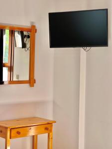 a flat screen tv hanging on a wall next to a table at Marinos Studios and Apartments in Gialiskari