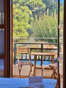 a room with a table and a bench on a balcony at Marinos Studios and Apartments in Gialiskari