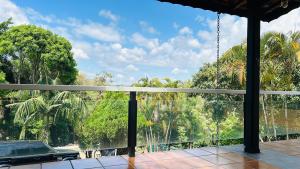 a balcony with a view of trees and a car at Chacara pé na agua represa de Mairiporã in Mairiporã