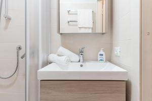 a bathroom with a white sink and a shower at Mono Fiorrancino in Folgaria +29 photos