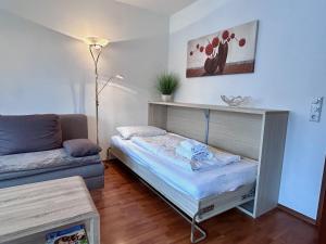 a living room with a bed and a couch at Ferienwohnung Kleine Seeperle - Ihr Rückzugsort in Nonnenhorn in Nonnenhorn