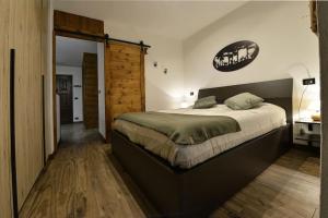 a bedroom with a large bed and a wooden door at Le Jardin des Montagnes in Morgex