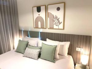 a bedroom with a bed with white and green pillows at Denia Apartment Rental - Vivir La Vida in Denia +32 photos