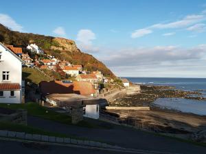 a town on a hill next to the ocean at The Firs Guesthouse in Runswick