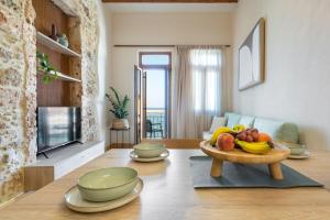 a living room with a table with a bowl of fruit at Leo Apartment 2 bdr apt overlooking the harbor in Chania