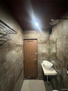 a bathroom with a sink and a wooden door at HOTEL PREMIER CHOICE - JUST 50 Meters FROM AJMER SHARIF DARGAH in Ajmer