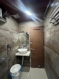 a bathroom with a sink and a toilet and a light at HOTEL PREMIER CHOICE - JUST 50 Meters FROM AJMER SHARIF DARGAH in Ajmer