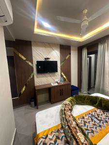 a living room with a couch and a flat screen tv at HOTEL PREMIER CHOICE - JUST 50 Meters FROM AJMER SHARIF DARGAH in Ajmer