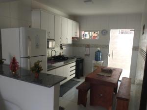 eine Küche mit einem Kühlschrank und einem Tisch darin in der Unterkunft Home Sweet Home Gravatá in Gravatá