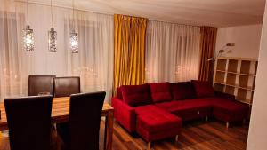 a living room with a red couch and a table at Ferienwohnung in der Altstadt,3 in Annaberg-Buchholz