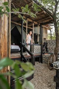 una donna in piedi su un'altalena in una tenda di Grace of Africa, Couples 5 STAR Nature Lodge a Marloth Park