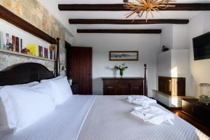 a bedroom with a large white bed with towels on it at Villa Vicanti in Pylos +70 photos