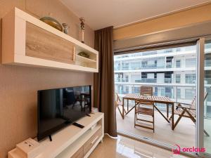 a living room with a flat screen tv and a table at Costa Élite in Cabanes