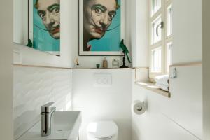 un bagno con due poster appesi al muro e servizi igienici di Villa Casa Katharina a Vižinada Altre 38 foto