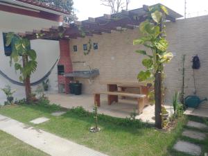 einen Hinterhof mit einem Picknicktisch und einer Bank in der Unterkunft Home Sweet Home Gravatá in Gravatá